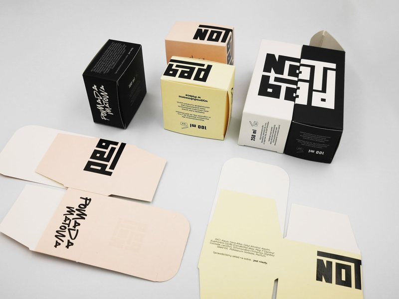 Tuck-end boxes for hair pomade next to the flat die-cut blanks before folding